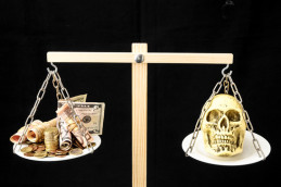 scale with skull and money