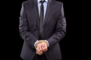 Man in suit with hands tied in criminal trial